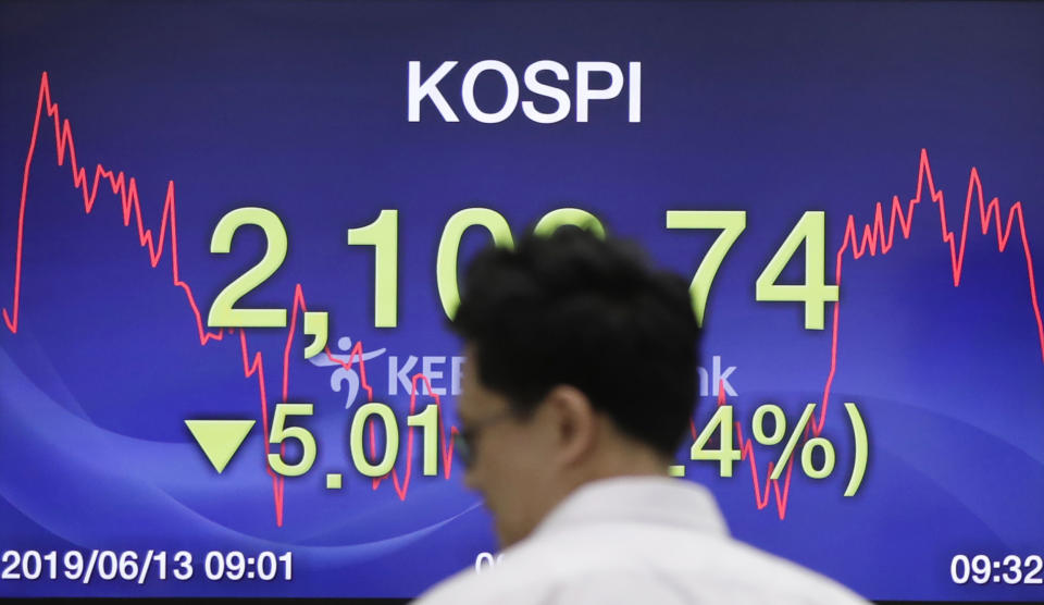 A currency trader walks by the screen showing the Korea Composite Stock Price Index (KOSPI) at the foreign exchange dealing room in Seoul, South Korea, Thursday, June 13, 2019. Asian stocks were mixed on Thursday as protesters in Hong Kong vowed to keep opposing a proposed extradition bill they fear would whittle down the territory’s legal autonomy. (AP Photo/Lee Jin-man)