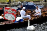 Officials take a break during the annual counting of the Queen's swans, known as 'Swan Upping' along the River Thames in London