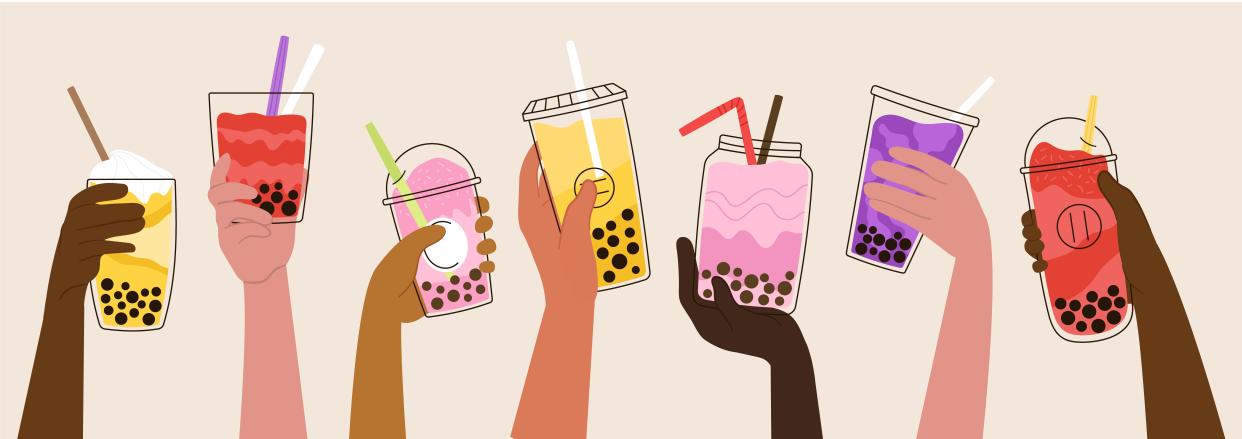 Hands hold bubble tea drinks.
