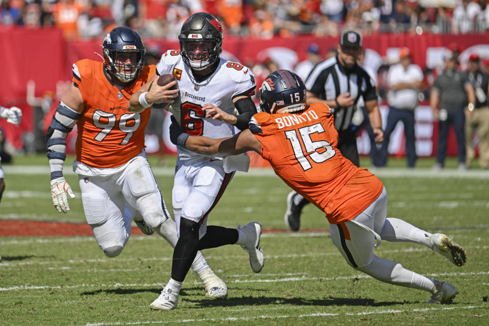 Tampa Bay Buccaneers quarterback Baker Mayfield (6) is stopped as he tries to get between Denver Broncos linebacker Nik Bonitto (15) and defensive end Zach Allen (99) during the second half of an NFL football game, in Tampa, Fla. on Sunday, Sept. 22, 2024. (AP Photo/Jason Behnken)