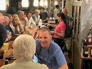 Newly shorn, Ogunquit Selectman Rick Dolliver mingles from behind the bar counter at his restaurant on Wednesday, Sept. 28, 2022. As part of his efforts to raise big bucks for the Maine Children's Cancer Program, Dolliver got his first haircut in more than two years that evening.