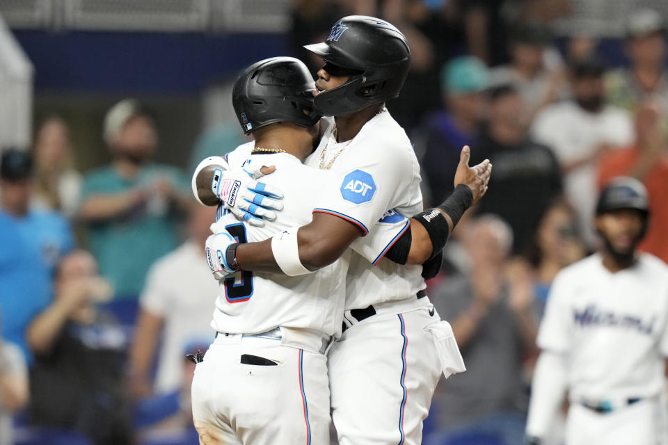 Miami Marlins' Jorge Soler, right, is hugged by Luis Arraez, left, after they scored on a two-run home run hit by Soler during the third inning of a baseball game against the Toronto Blue Jays, Monday, June 19, 2023, in Miami. (AP Photo/Lynne Sladky)