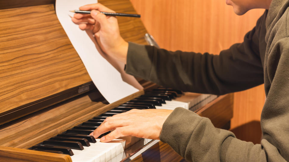 Person at piano writing a song