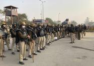 Indian policemen get briefing from their officer during a blockade by Indian farmers at the Delhi-Haryana state border, Monday, Nov. 30, 2020. Indian Prime Minister Narendra Modi tried to placate thousands of farmers protesting new agriculture laws Monday and said they were being misled by opposition parties and that his government would resolve all their concerns. (AP Photo/Rishi Lekhi)