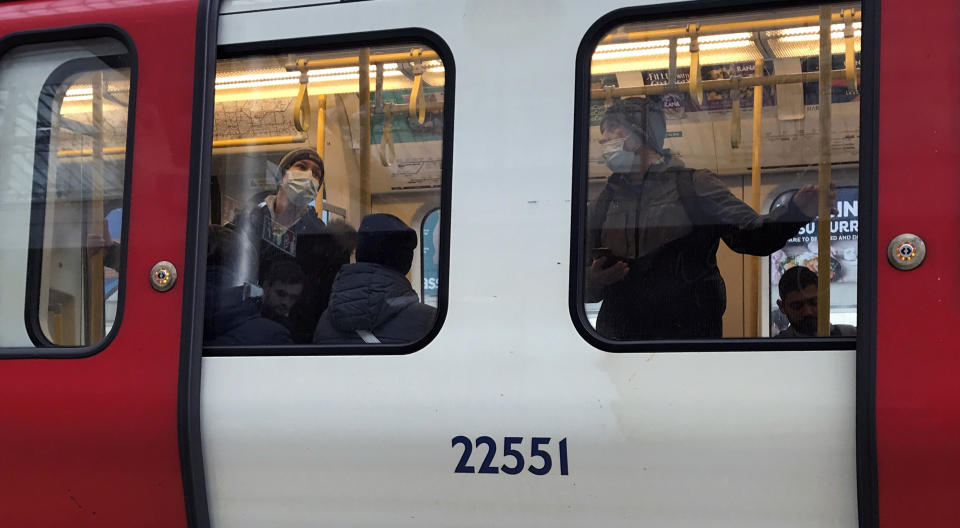 People wear masks as they travel on a tube in London, Friday, March 13, 2020. For most people, the new coronavirus causes only mild or moderate symptoms, such as fever and cough. For some, especially older adults and people with existing health problems, it can cause more severe illness, including pneumonia. (AP Photo/Kirsty Wigglesworth)