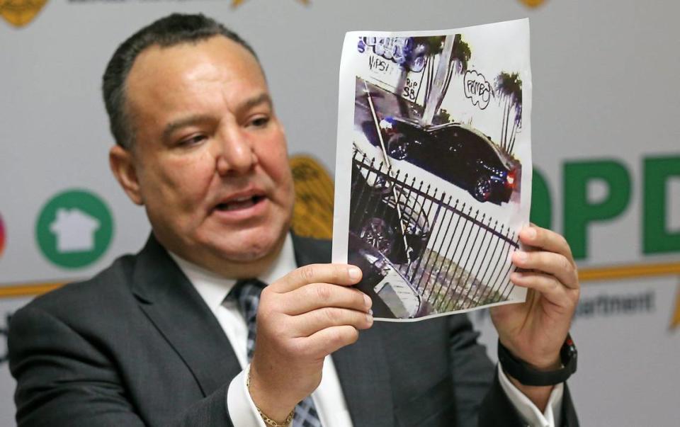 Miami-Dade Homicide Detective Juan Segovia holds up a photograph of a car during a press conference at Miami-Dade Police Department on Friday asking the public for help finding the person who killed Melissa Gonzalez. Police said the car was spotted driving within a three-block radius of the shooting.