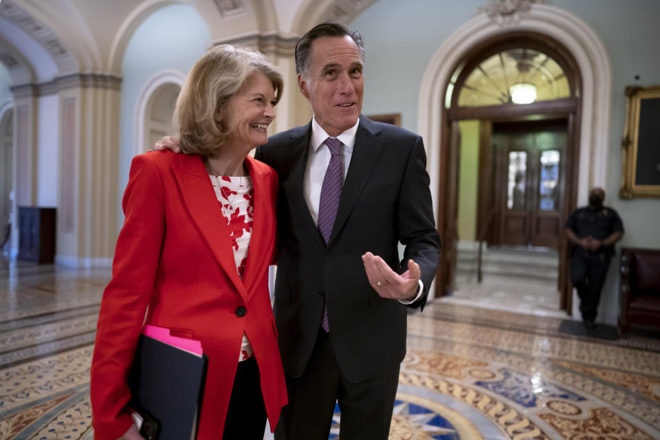 FILE - Republican Senators Lisa Murkowski of Alaska, left, and Mitt Romney of Utah, who smile as they greet each other outside the chamber, at the Capitol in Washington, April 5, 2022. Murkowski and Romney join Sen. Susan Collins, R-Maine, who is also bucking the GOP leadership in giving President Joe Biden's nominee a new burst of bipartisan support to become the first Black woman on the high court. (AP Photo/J. Scott Applewhite)