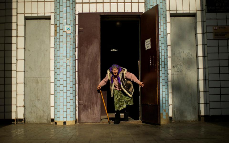 A woman, fleeing from an area near the front line in Donetsk, prepares to board a bus in Kurakhove, eastern Ukraine - AP