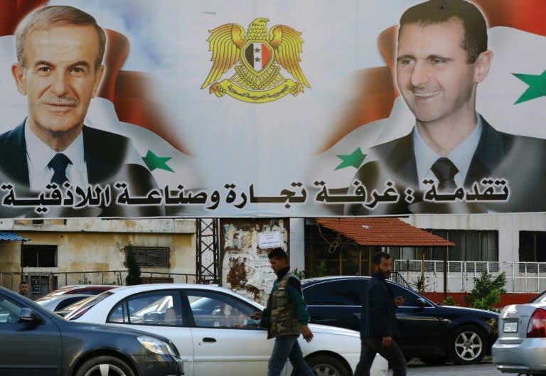 A billboard shows pictures of Syrian President Bashar al-Assad (R) and his late father former president Hafez in the coastal city of Latakia, a stronghold of his Alawite sect and Shiites