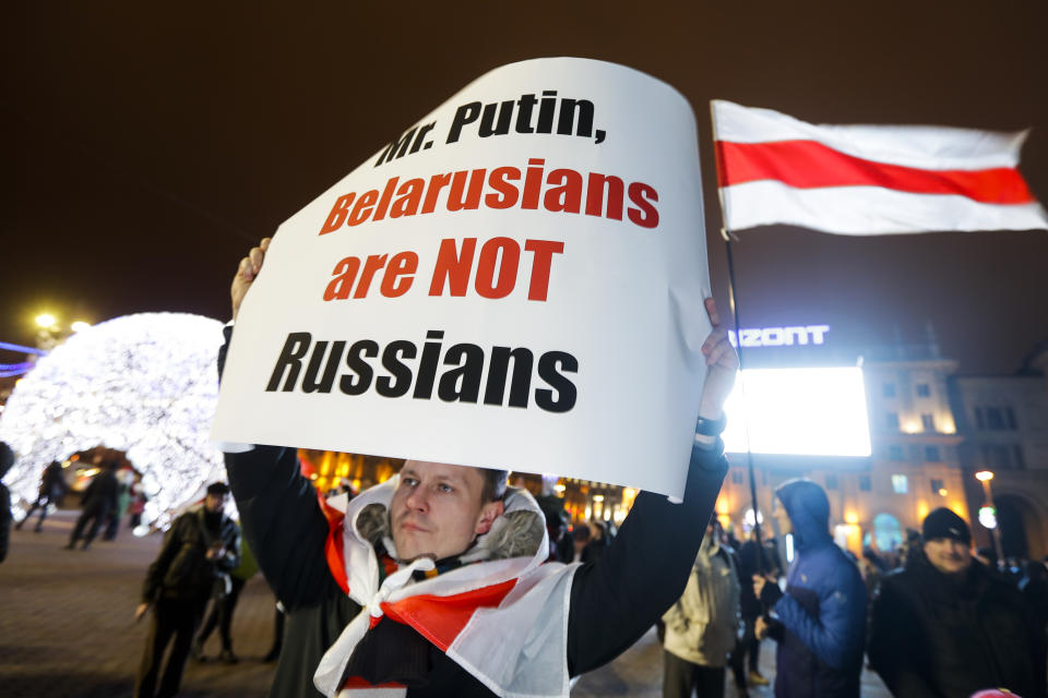 A Belarusian demonstrator holds a poster as other gather to protest closer integration with Russia, which protesters fear could erode the post-Soviet independence of Belarus, in downtown in Minsk, Belarus, Friday, Dec. 20, 2019. The presidents of Belarus and Russia have met to discuss deeper economic ties between the two close allies amid mounting concerns in Minsk that Moscow ultimately wants to subdue its neighbor. (AP Photo/Sergei Grits)