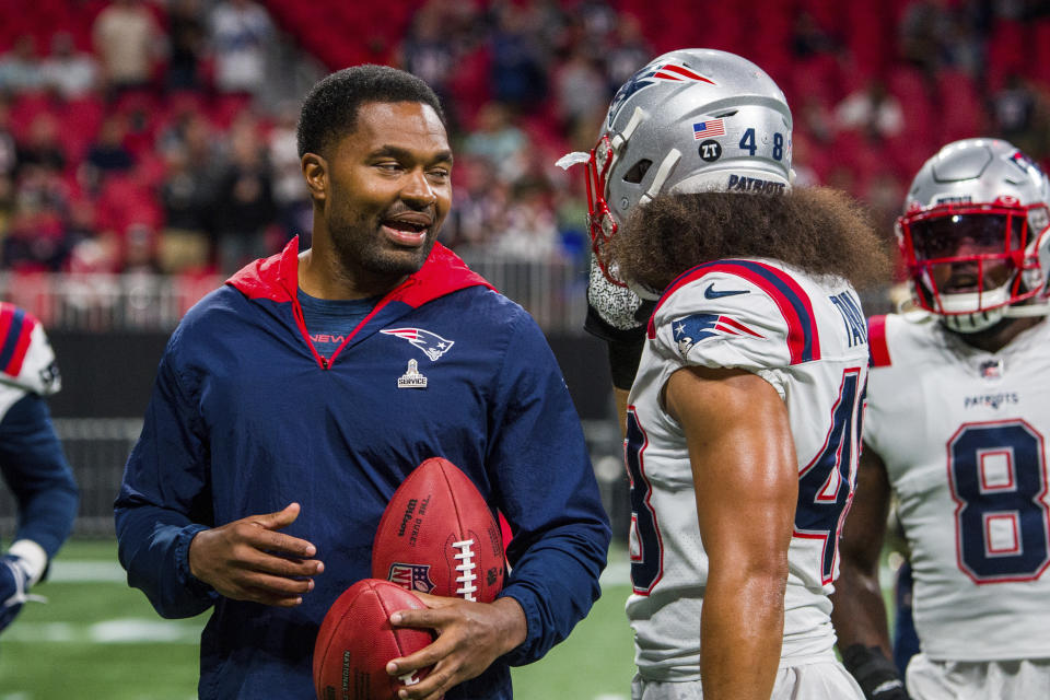 New England Patriots inside linebackers coach Jerod Mayo speaks with linebacker Jahlani Tavai (48) before an NFL football game against the Atlanta Falcons, Thursday, Nov. 18, 2021, in Atlanta. (AP Photo/Danny Karnik)