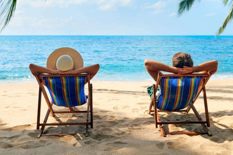 Couple relax on the beach enjoy beautiful sea on the tropical island. Getty Images