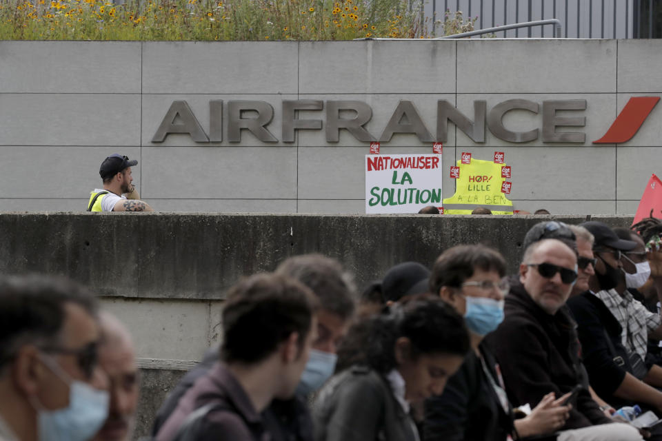 Air France workers gather during a protest in front of the company headquarters in Tremblay-en-France, outside Paris Friday, July 3, 2020. Air France is meeting with personnel representatives Friday to discuss thousands of job cuts after the virus pandemic grounded most flights and darkened prospects for future air travel. (AP Photo/Christophe Ena)