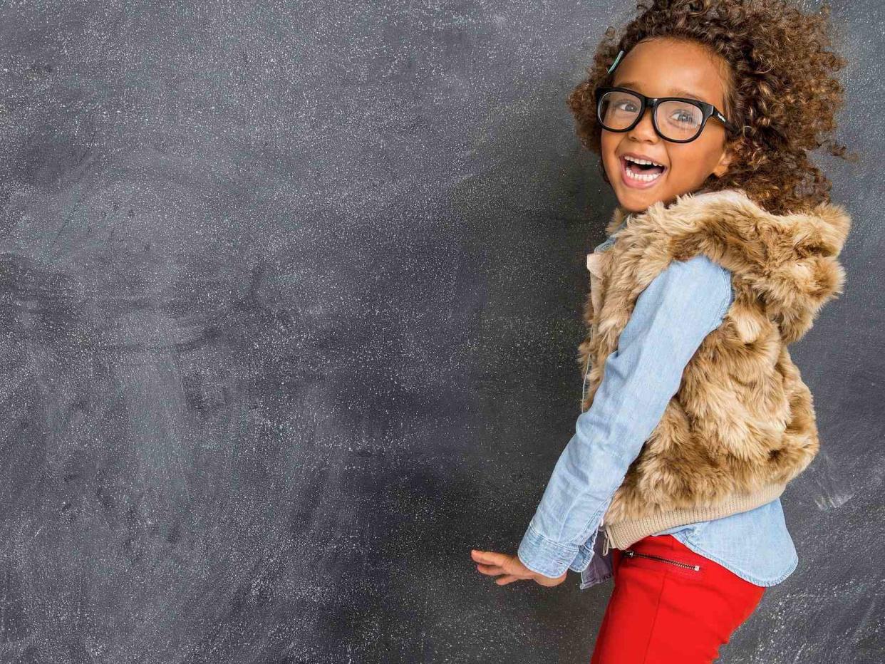 Young Girl Jumping Red Pants Fur Jacket and Glasses