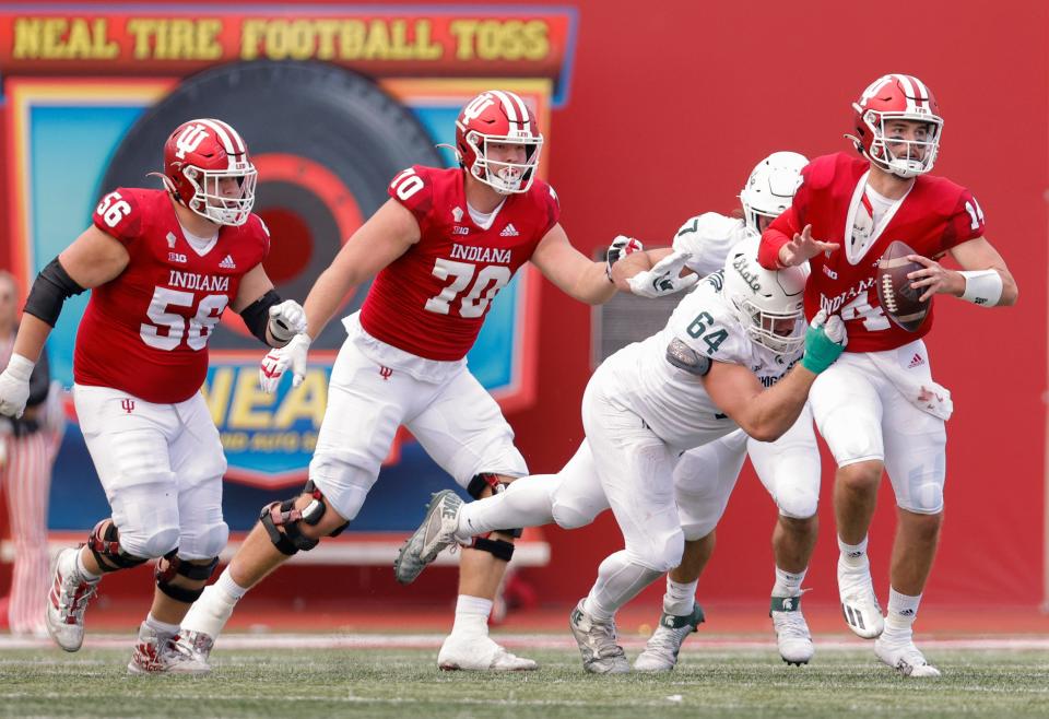 Jack Tuttle (14) of the Indiana Hoosiers is nearly sacked by Jacob Slade of the Michigan State Spartans during the second half at Memorial Stadium on Oct.16, 2021 in Bloomington, Indiana.