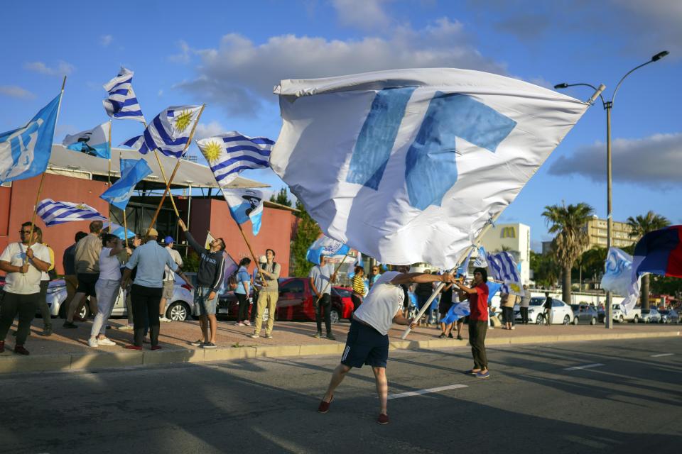 Seguidores del candidato presidencial del Partido Nacional, Luis Lacalle Pou, agitan banderas del partido un día antes de la segunda vuelta electoral en Montevideo, Uruguay, el sábado 23 de noviembre de 2019. (AP Foto/Matilde Campodónico)