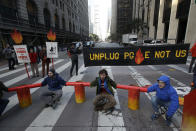 FILE - In this Dec. 16, 2019, file photo, protesters block traffic on Beale Street where a Pacific Gas & Electric building is located in San Francisco. Newsom is wrapping up a first year highlighted by the bankruptcy of the country's largest utility, an escalating homelessness crisis and an intensifying feud with the Trump administration, along with record-low unemployment and a booming state economy producing a multi-billion-dollar surplus. (AP Photo/Jeff Chiu, File)