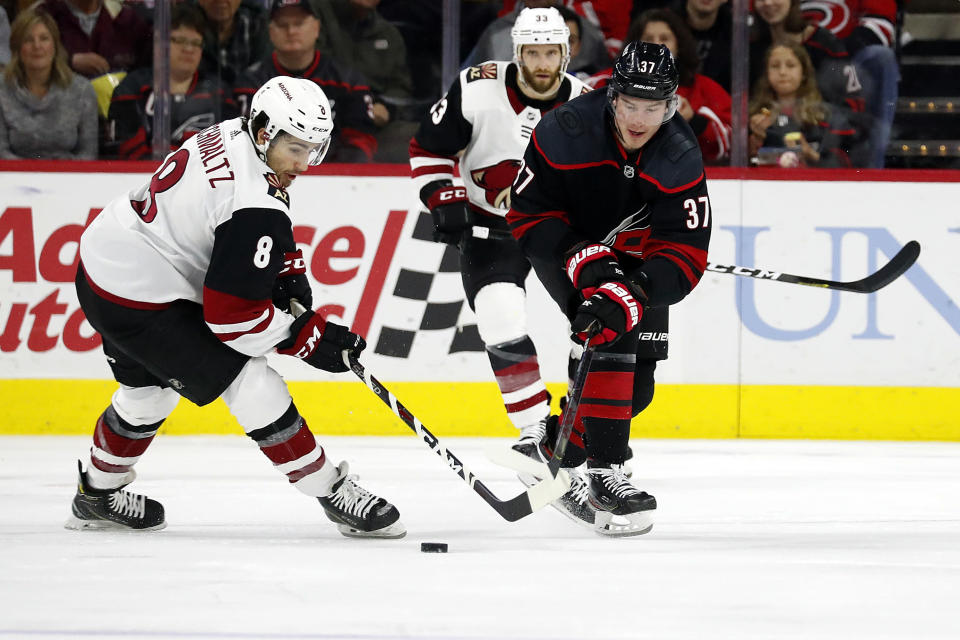 Carolina Hurricanes' Andrei Svechnikov (37), of Russia, battles Arizona Coyotes' Nick Schmaltz (8) for the puck during the second period of an NHL hockey game in Raleigh, N.C., Friday, Jan. 10, 2020. (AP Photo/Karl B DeBlaker)