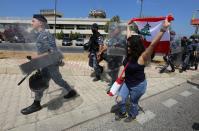 A demonstrator holds a Lebanese flag during a protest against the government performance and worsening economic conditions near the presidential palace in Baabda