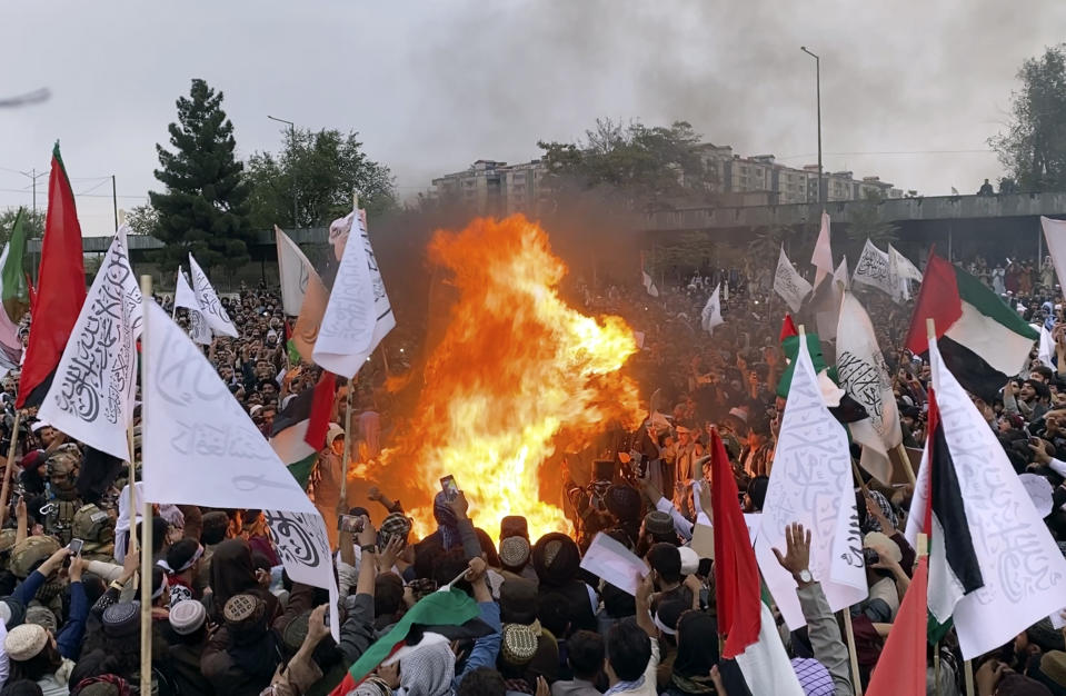 Afghans protesters burn representations of US and Israeli flags during a protest against Israeli airstrikes on Gaza, while holding a demonstration to show solidarity with Palestinian people, in Kabul, Afghanistan, Friday, Oct. 13, 2023. (AP Photo/ Siddiqullah Alizai)