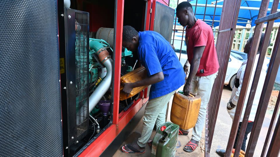 Men pour diesel from jerrycans to a generator in Niamey on Monday. - AFP/Getty Images