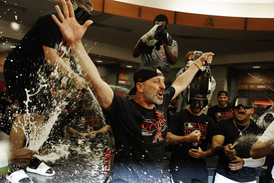 The Arizona Diamondbacks manager Torey Lovullo celebrates with players and coaches in the locker room after clinching a Wild Card spot in the MLB playoffs after a baseball game against the Houston Astros Saturday, Sept. 30, 2023, in Phoenix. The Astros won 1-0. (AP Photo/Ross D. Franklin)