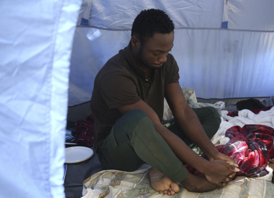 Daniel Ejube, from Cameroon, sits inside a tent he has been living in with compatriot Enjei Grace for nearly five months inside a section of a United Nations controlled buffer zone that cuts across ethnically divided Cyprus' capital Nicosia on Wednesday, Oct. 20, 2021. Grace and Ejube have been stuck in a legal limbo inside the buffer zone that separates Cyprus' breakaway north from the internationally recognized south. The U.N. refugee agency says Grace and Ejube should be allowed to apply for asylum in the south. (AP Photo/Philippos Christou)