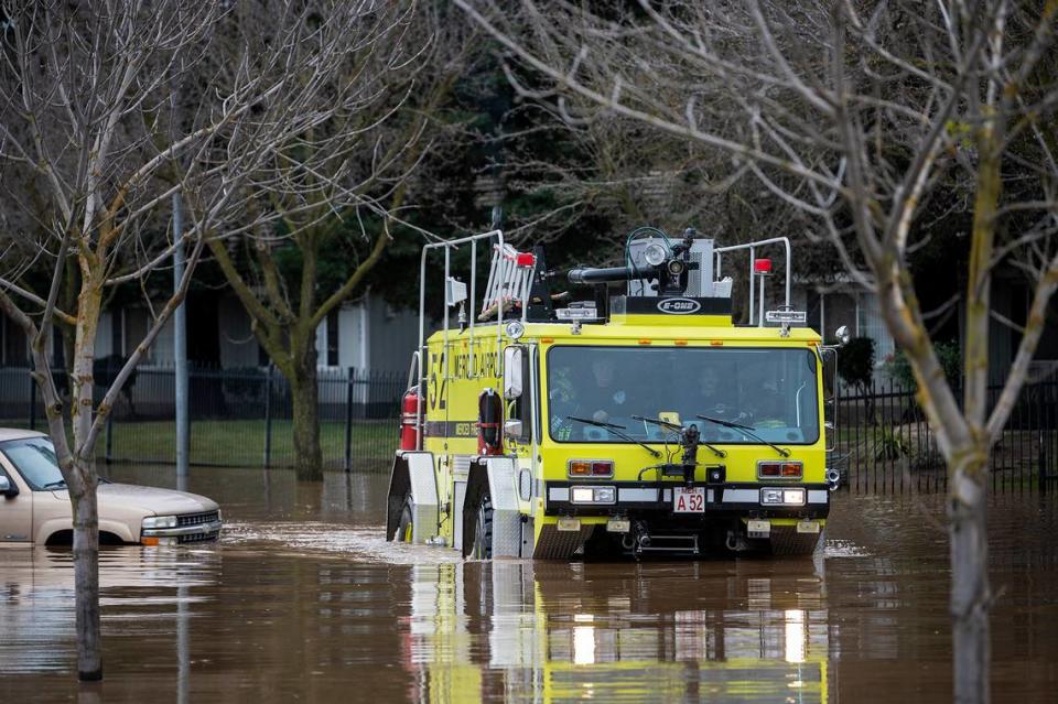 A Merced airport vehicle navigates floodwater along Willowbrook Drive near Carol Gabriault park in Merced, Calif., on Wednesday, Jan. 11, 2023.