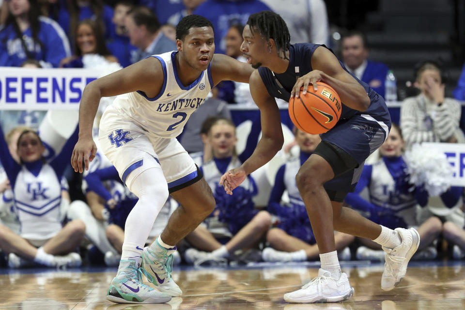 North Florida's Jarius Hicklen, right, looks for an opening on Kentucky's Sahvir Wheeler (2) during the first half of an NCAA college basketball game in Lexington, Ky., Wednesday, Nov. 23, 2022. (AP Photo/James Crisp)