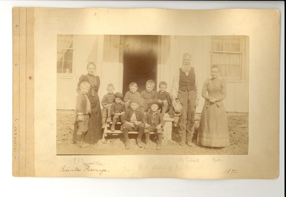 This is a page from an early photograph album kept by Frances Louisa Goodrich. The album records Goodrich's first mission posting in the Riceville/Brittain's Cove area of Buncombe County. The caption across the bottom of the page reads: "Riceville Parsonage...First N.C. station of F. L. Goodrich...1892." Very lightly in pencil, the adults are identified as F. L. G. , "Mr. Roberts," and "Grace."