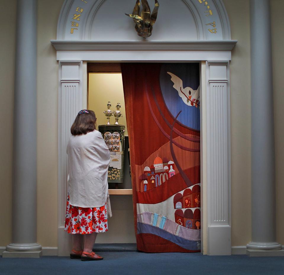 Rabbi Shira Joseph closes the drapes on the ark that contains the synagogue's Torah.