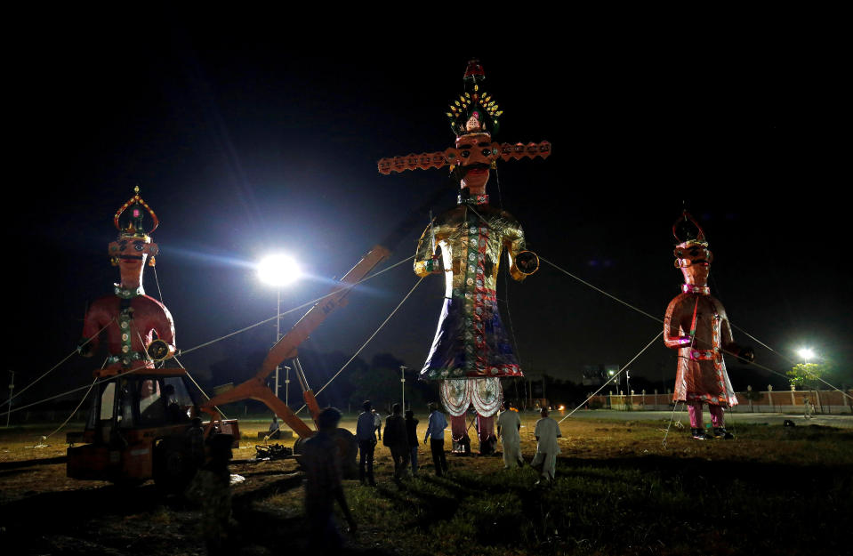 <p>Workers install effigies of the demon King Ravana, his son Meghnad (L) and brother Kumbhkarana (R) before they are set on fire during the Hindu festival of Dussehra, in Ahmedabad, India, Sept. 29, 2017. (Photo: Amit Dave/Reuters) </p>