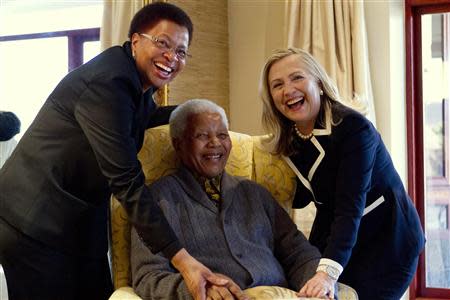 U.S. Secretary of State Hillary Clinton (R) poses for a photograph with Nelson Mandela, 94, former president of South Africa, and his wife Graca Machel at his home in Qunu in this August 6, 2012 file photo. REUTERS/Jacquelyn Martin/Pool/Files
