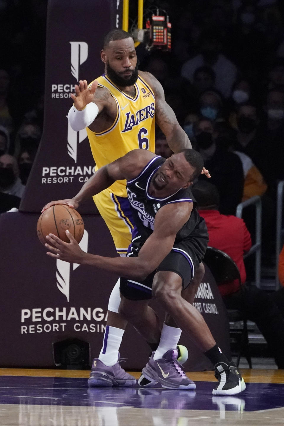 Sacramento Kings forward Harrison Barnes, right, is fouled by Los Angeles Lakers forward LeBron James (6) during the first half of an NBA basketball game Tuesday, Jan. 4, 2022, in Los Angeles. (AP Photo/Marcio Jose Sanchez)