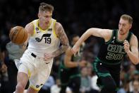 Utah Jazz's Luka Samanic (19) drives past Boston Celtics' Sam Hauser (30) during the first half of an NBA basketball game Friday, March 31, 2023, in Boston. (AP Photo/Michael Dwyer)