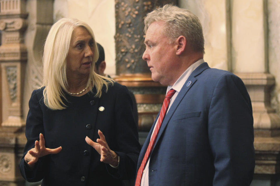 Kansas Senate Commerce Committee Chair Renee Erickson, left, R-Wichita, confers with House Commerce Committee Chair Sean Tarwater, right, R-Stilwell, during a break in the Senate's session, Tuesday, April 30, 2024, at the Statehouse in Topeka, Kan. The two lawmakers have helped draft a proposal designed to assist the Kansas City Chiefs football team and the Kansas City Royals baseballs team finance new stadiums in Kansas. (AP Photo/John Hanna)