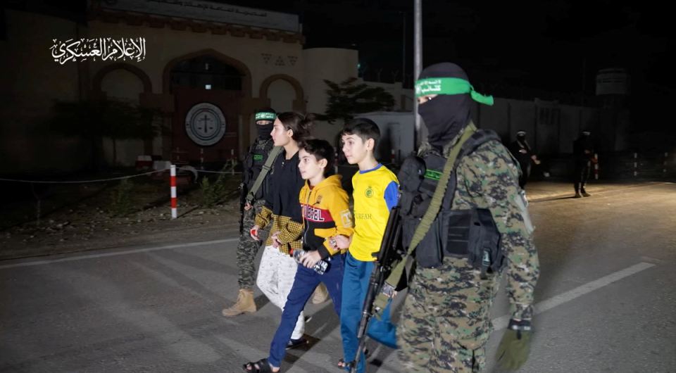 Hostages being handed over by Hamas militants on Monday night (via REUTERS)