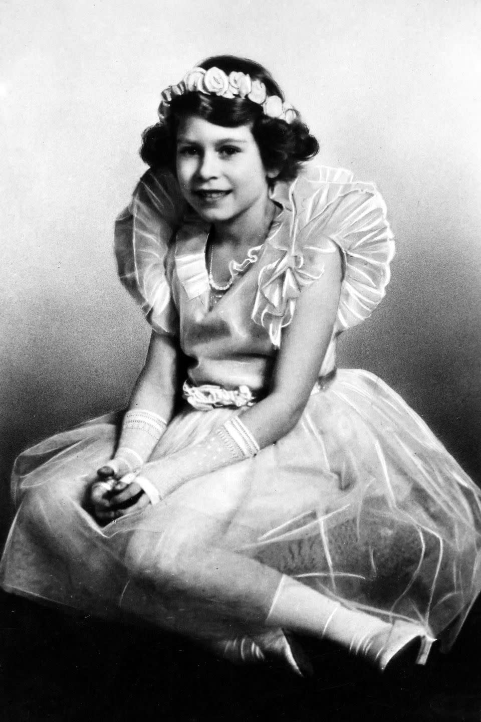 <p>In an adorable ballerina outfit with a floral crown and fingerless gloves. At the time of this photograph, she was Princess Elizabeth, daughter of The Duke and Duchess of York.</p>