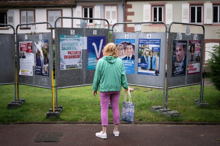 Une femme regarde les affiches électorales des candidats aux législatives à Wissembourg, le 30 juin 2024 dans le Bas-Rhin (SEBASTIEN BOZON)