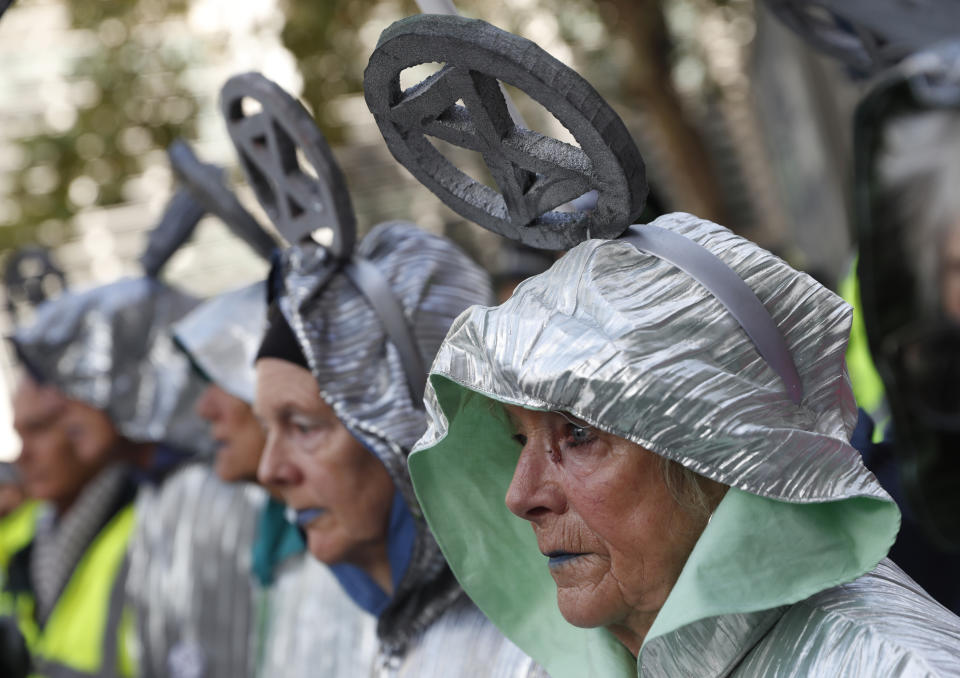 Climate change protesters stand in line outside the Home Office in London, Tuesday, Oct. 8, 2019. Police are reporting they have arrested more than 300 people at the start of two weeks of protests as the Extinction Rebellion group attempts to draw attention to global warming .(AP Photo/Alastair Grant)