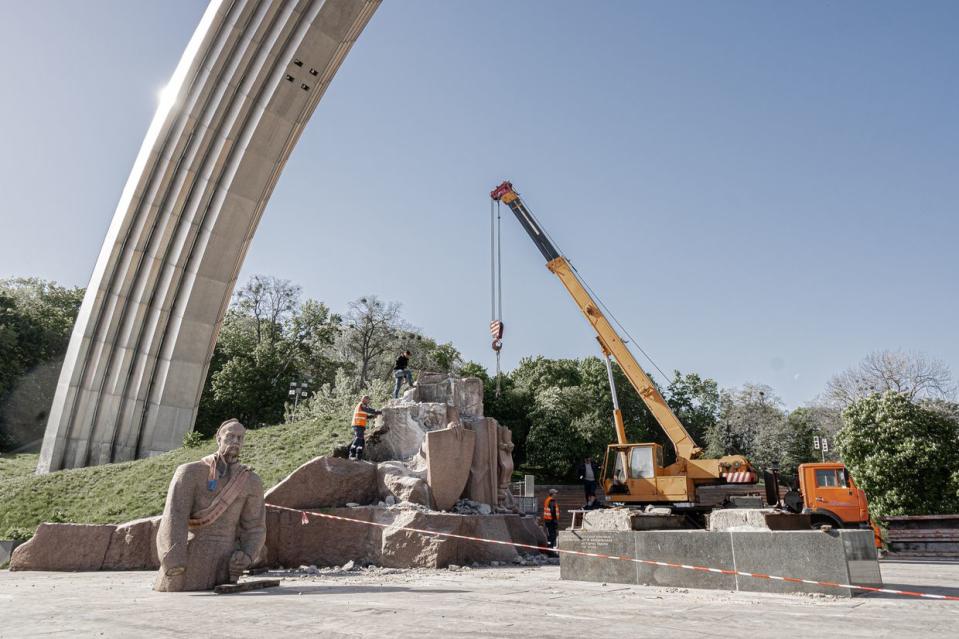 Municipal service workers under the Arch of Freedom of the Ukrainian People finish dismantling a granite monument with a multi-figure group dedicated to the Pereiaslav Council in Kyiv, Ukraine, on May 1, 2024. (Zinchenko/Global Images Ukraine via Getty Images)