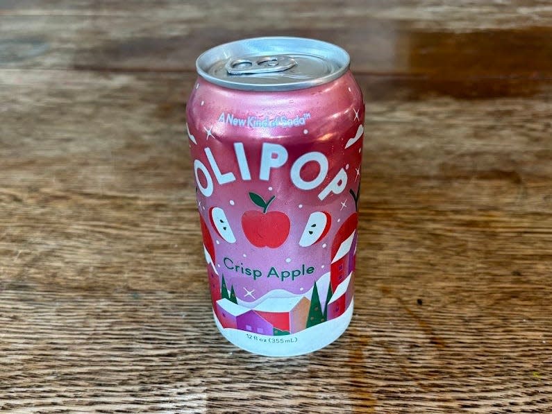 A can of crisp-apple Olipop on a wooden table.
