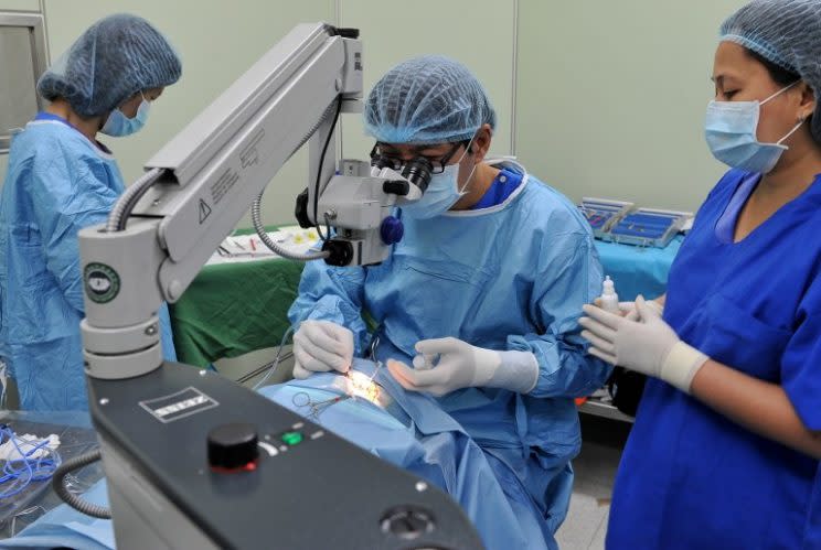 Opthalmologist George Co from the University of Santo Tomas removes a cataract from the eye of 43 year-old Marisol Leona, during surgery in Manila on January 16, 2011. Volunteer doctors from the University of Santo Tomas in cooperation with a Buddhist Tzu Chi foundation operated on 400 patients for free to remove cataracts during an outreach programme in conjunction with the 400 year anniversary of the University of Santo Tomas, which has the oldest extant university charter in Asia. AFP PHOTO / JAY DIRECTO / AFP PHOTO / JAY DIRECTO