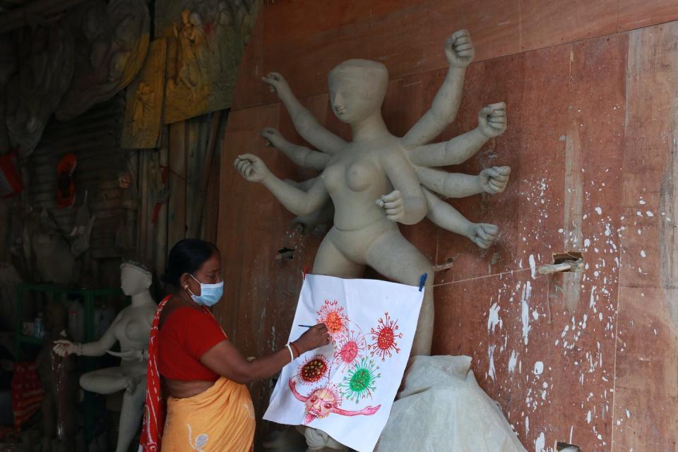 <span class="caption">A woman puts the finishing touch to a painting depicting coronavirus.</span> <span class="attribution"><a class="link " href="https://www.gettyimages.com/detail/news-photo/indian-women-artist-finishing-touches-to-a-panting-of-the-news-photo/1212461322?adppopup=true" rel="nofollow noopener" target="_blank" data-ylk="slk:Debajyoti Chakraborty/NurPhoto via Getty Images;elm:context_link;itc:0;sec:content-canvas">Debajyoti Chakraborty/NurPhoto via Getty Images</a></span>