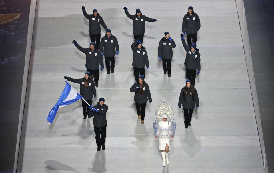 Cristian Simari Birkner of Argentina holds his country's national flag and enters the arena with his team during the opening ceremony of the 2014 Winter Olympics in Sochi, Russia, Friday, Feb. 7, 2014. (AP Photo/Charlie Riedel)