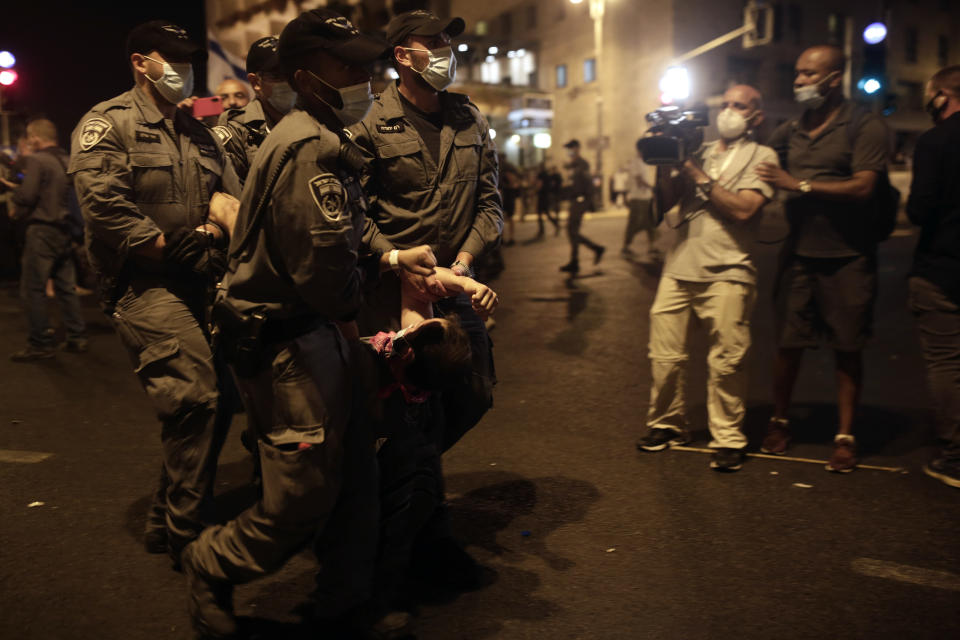 Police carry a protester away as they clear the square outside of Prime Minister Benjamin Netanyahu's residence in Jerusalem, late Saturday, Aug. 22, 2020. (AP Photo/Maya Alleruzzo)