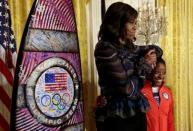 2016 Olympic individual all-around gymnast Simone Arianne Biles reacts next to First lady Michelle Obama as President Barack Obama (unseen) welcomes U.S. Olympic and Paralympics teams at the White House in Washington, U.S., September 29, 2016. REUTERS/Yuri Gripas