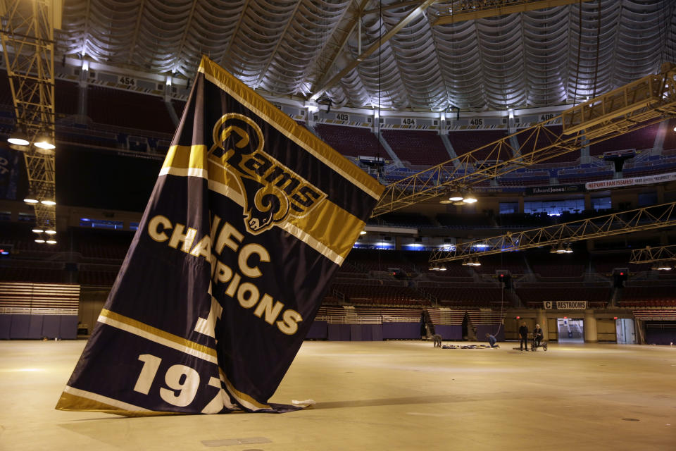 FILE - Championship banners are removed from the ceiling of the Edward Jones Dome in St. Louis, former home of the St. Louis Rams football team, Jan. 14, 2016. Representatives of St. Louis, St. Louis County and the authority that owns The Dome at America’s Center have reached a tentative agreement dividing up the $519 million remaining in settlement money from the lawsuit over the NFL Rams’ relocation. (AP Photo/Jeff Roberson, File)