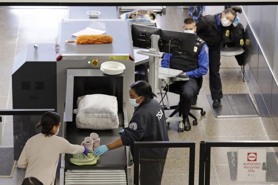 Agentes de la TSA inspeccionan pasajeros en el aeropuerto Seattle-Tacoma el15 de abril de 2020(AP /Elaine Thompson)