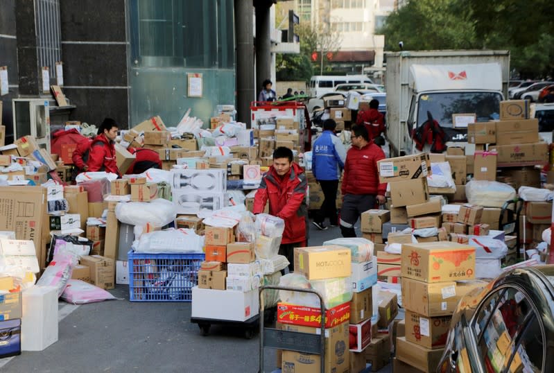 FILE PHOTO: Deliverymen of JD.com work among parcels beside a road after the 11.11 Singles' Day shopping festival